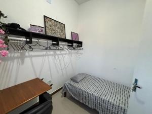 a bedroom with a bed and a table and a desk at Suíte Elegante e Aconchegante in Guarulhos