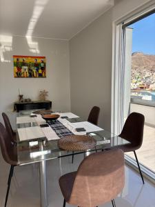 Un comedor con una mesa de cristal y sillas. en Matiota Beach Penthouse, en Mindelo