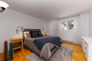 una camera da letto con un letto grande e una finestra di La Source Enchantée a Baie-Saint-Paul
