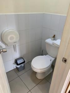 a white bathroom with a toilet and a trash can at Valparaíso Plan, cercano al Congreso Nacional in Valparaíso +35 photos