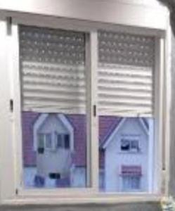 una ventana de una casa con una casa blanca en Belle vue Belle situation, en Ifrane 1 foto más