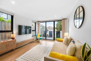 a living room with a couch and a tv at XV - Sun Soaked Ultimate Bentleigh Convenience in Melbourne