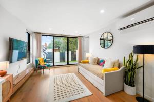 a living room with a couch and a large window at XV - Sun Soaked Ultimate Bentleigh Convenience in Melbourne