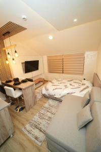 Un dormitorio con una cama y un escritorio con una computadora. en Residence Hill - Planinski Kutak, en Kopaonik