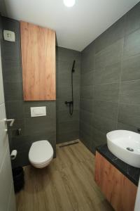 Un baño con un inodoro blanco y un lavabo. en Residence Hill - Planinski Kutak, en Kopaonik 11 fotos más