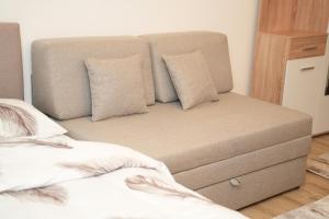 a couch sitting next to a bed in a bedroom at Residence Hill - Planinski Kutak in Kopaonik