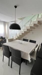 a dining table and chairs in a room with stairs at Apartamento de luxo no Guaruja in Guarujá +15 photos