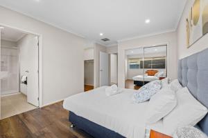 1 dormitorio blanco con 1 cama grande y sala de estar en Hartleigh Estate - Sophisticated Family Living, en Clyde