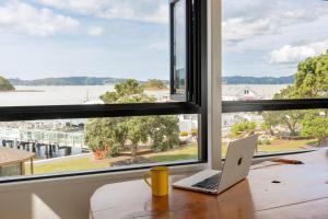a laptop sitting on a table in front of a window at Haka House Bay of Islands in Paihia