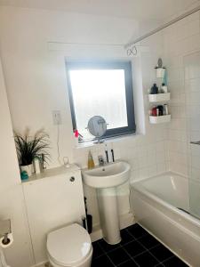 a bathroom with a toilet and a sink and a tub at Mareot House UK in Havering atte Bower