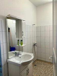 Un baño blanco con lavabo y espejo. en La Brise du Levant, en Capesterre 7 fotos más