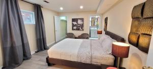 a bedroom with a bed and chairs in it at Holiday Hideout Basement Unit in Pickering