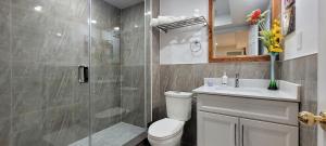 a bathroom with a shower and a toilet and a sink at Holiday Hideout Basement Unit in Pickering +40 photos
