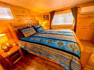 a bedroom with a bed in a log cabin at Yellowstone Treasure Guesthouses on the River in Gardiner