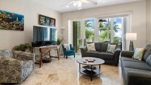 a living room with couches and a television and a table at 405 Mariners Club in Key Largo