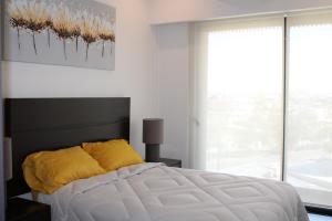 a bedroom with a white bed with a yellow pillow at Loft Cerca Plaza Mayor in Miravalle