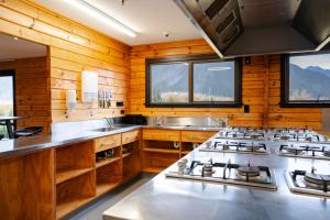 a kitchen with wooden walls and a stove top oven at Haka House Hostel Aoraki Mt Cook in Mount Cook Village +31 photos
