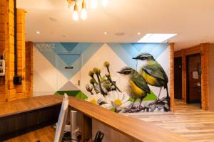 a wall with paintings of birds on it in a store at Haka House Hostel Aoraki Mt Cook in Mount Cook Village