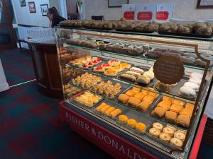 a display case filled with lots of different types of donuts at Lomond Hills Hotel & Health Club in Freuchie