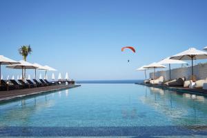 una piscina con sedie e ombrelloni di Glamp Nusa a Nusa Dua