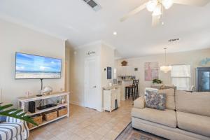 a living room with a couch and a flat screen tv at Captain's Chair 18A By Pkrm in Pensacola