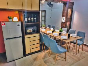 a dining room with a table and a refrigerator at Semi-Detached, Up to 24 Pax, 3200sqft, 4 Bedrooms, 3 Bathrooms, 4 Car Parks by Star Home in Gelugor