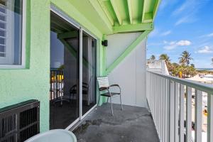 a balcony with a chair and a view of the beach at Oceanfront Inn Room #18- Ocean View Balcony 2 Full Beds in Fort Pierce