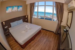 una camera d'albergo con un letto con un nastro sopra di Wave View Hotel a Semporna