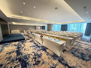 a large banquet hall with white tables and chairs at Spring ALacarte Ha Long Luxury Studio in Ha Long +24 photos