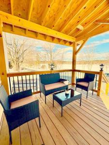 a wooden deck with chairs and a table on a porch at Cozy lake house in Nassau