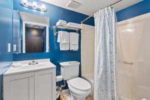 a bathroom with a toilet and a sink and a shower at Oceanfront Inn Room #22- Ocean View Balcony 2 Full Beds in Fort Pierce
