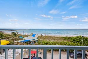 a view of the beach from the balcony of a resort at Oceanfront Inn Room #22- Ocean View Balcony 2 Full Beds in Fort Pierce