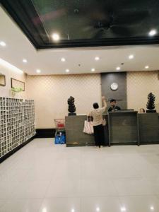 セブシティにあるJY Room Rentals Cebu SMRの待合室の窓口に立つ男