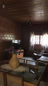 a living room with a table with a vase on it at Chácara João e Maria in Toledo