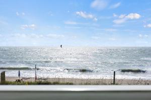 a beach with a bird flying over the ocean at Oceanfront Inn Room #24- Ocean View Balcony 2 Full Beds in Fort Pierce