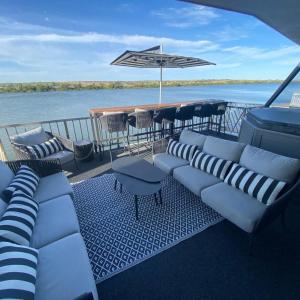a deck with couches and a bar on a boat at Wow Houseboats Pty Ltd in White Sands