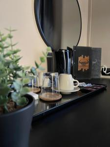 a table with cups and a coffee maker and a plant at The Steakhouse - Guest Rooms in Sankt Johann im Pongau
