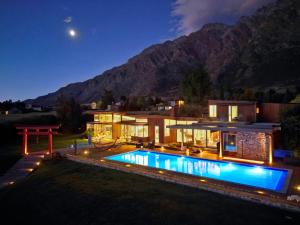 ein Haus mit Swimmingpool bei Nacht in der Unterkunft Oraka Lakeside Retreat by Sotheby's Luxury Rental Homes in Queenstown Airport