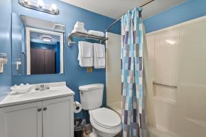 a bathroom with a toilet and a sink and a shower at Oceanfront Inn Room #17- Ocean View Balcony King Bed in Fort Pierce