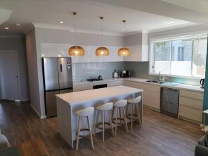 a kitchen with a large island with bar stools at Lakeside Haven Waterfront in Gorokan