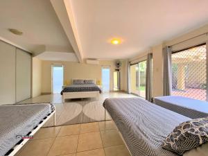 a large room with two beds and a couch at The Sandcastle in Burrum Heads