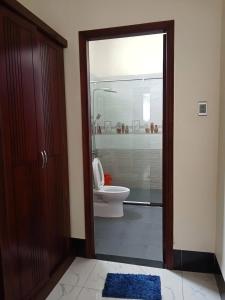 a bathroom with a toilet and a glass door at Trúc Huỳnh Hotel Tây Ninh in Tây Ninh