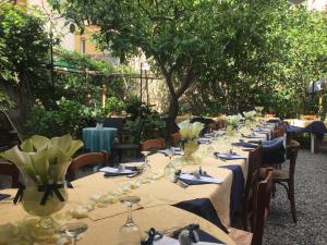 una fila de mesas con copas de vino y servilletas en Hotel Mimosa, en Alassio