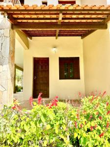 a house with a porch with flowers in front of it at Sítio Barra - Suíte Privada Independente 1 in Guaramiranga