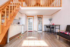 a room with a staircase and a kitchen and a living room at Ganghwa Western Beach Pension in Incheon