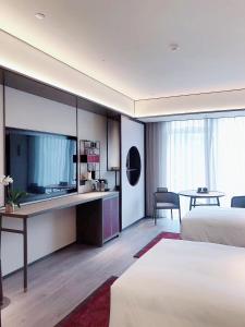 Voodi või voodid majutusasutuse JOYA Hangzhou Qianjiang New Town toas