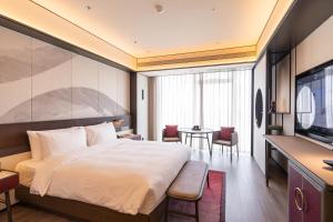 Televiisor ja/või meelelahutuskeskus majutusasutuses JOYA Hangzhou Qianjiang New Town