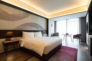 Voodi või voodid majutusasutuse JOYA Hangzhou Qianjiang New Town toas