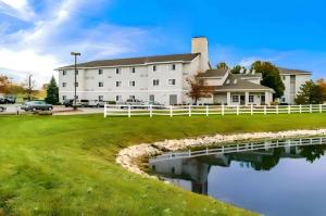 a large white building with a pond in front of it at Quality Inn Fishers - Indianapolis in Fishers