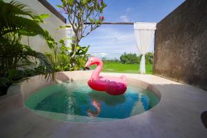 a pink inflatable flamingo in a pool of water at Ubu Villa Sujiva in Ngaglik